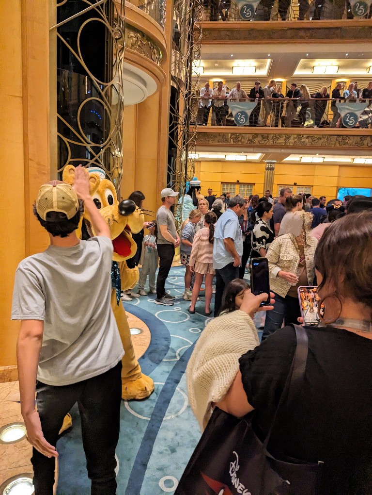 A large crowd makes impromptu lines to meet Disney Cruise Line characters in the ship lobby during 'Til We Meet Again