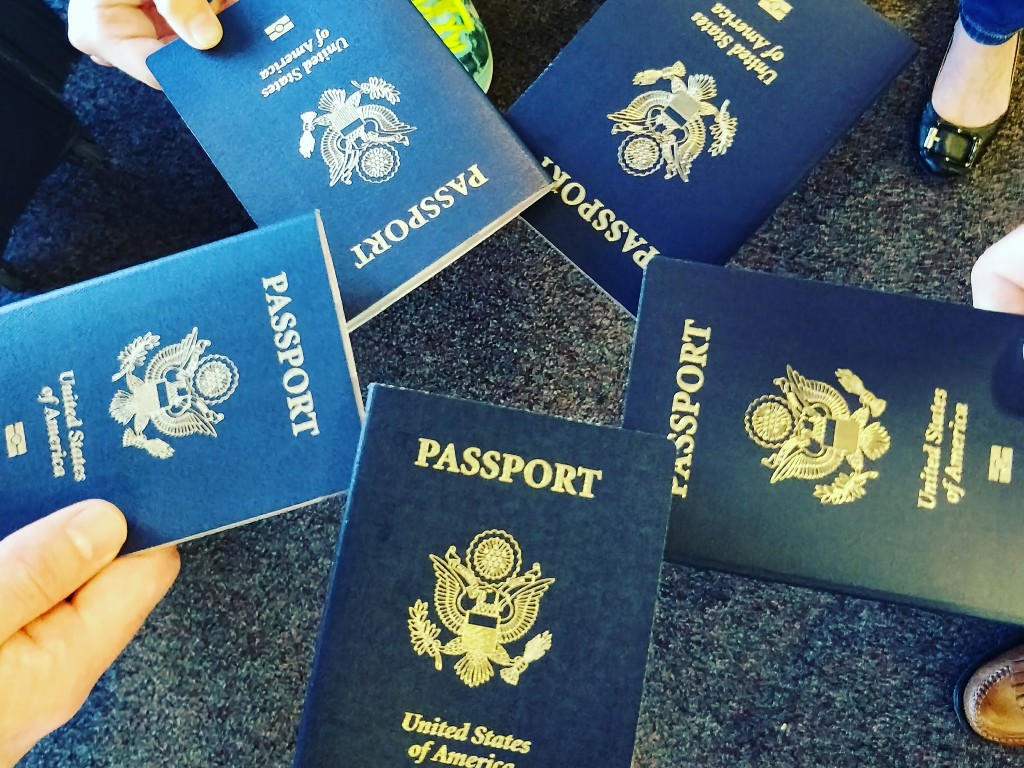 A group hold their passports in a circle before boarding a flight