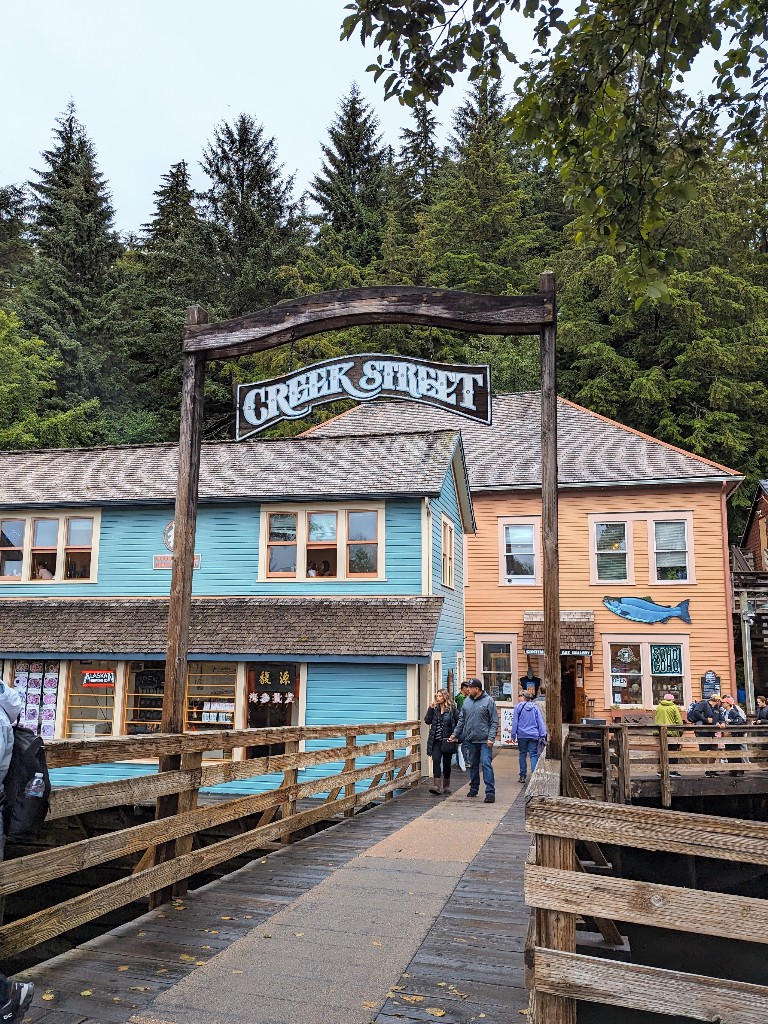 Creek Street sign in Ketchikan with colorful wooden buildings behind on a street built directly over the water