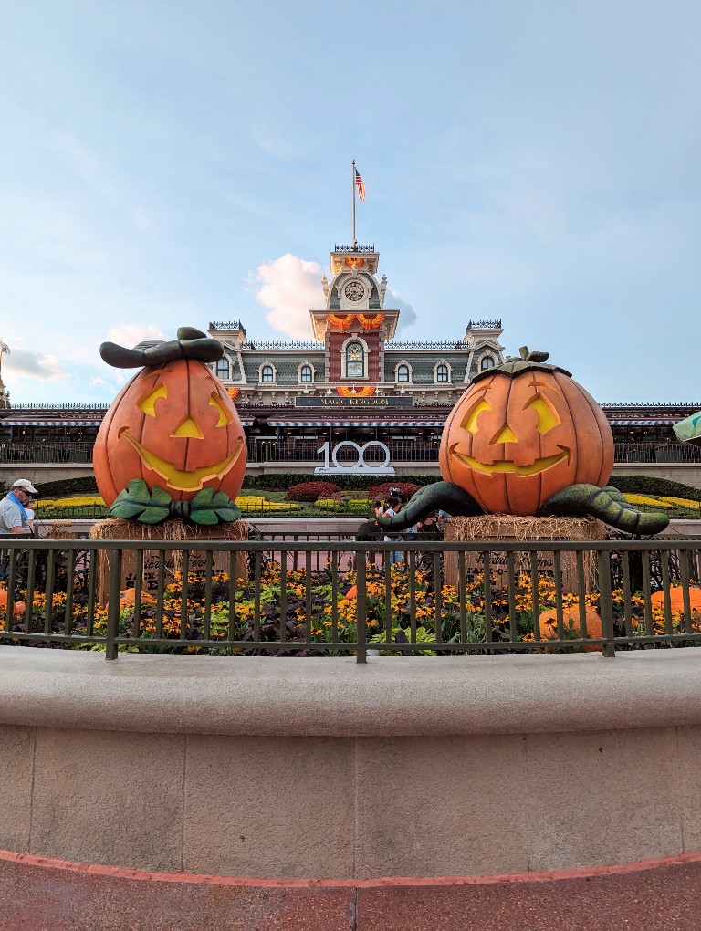 Two jack o'lanterns frame Magic Kingdom's train station full of Halloween decorations at Mickey's Not So Scary Halloween Party