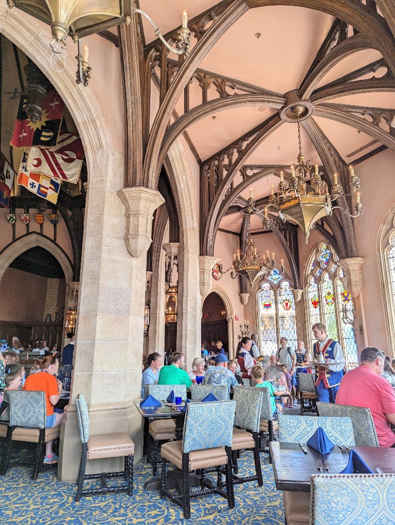 Carved wooden arches, stained glass windows, and intricately embellished chandeliers make for an impressive atmosphere at Cinderella's Royal Table princess meals