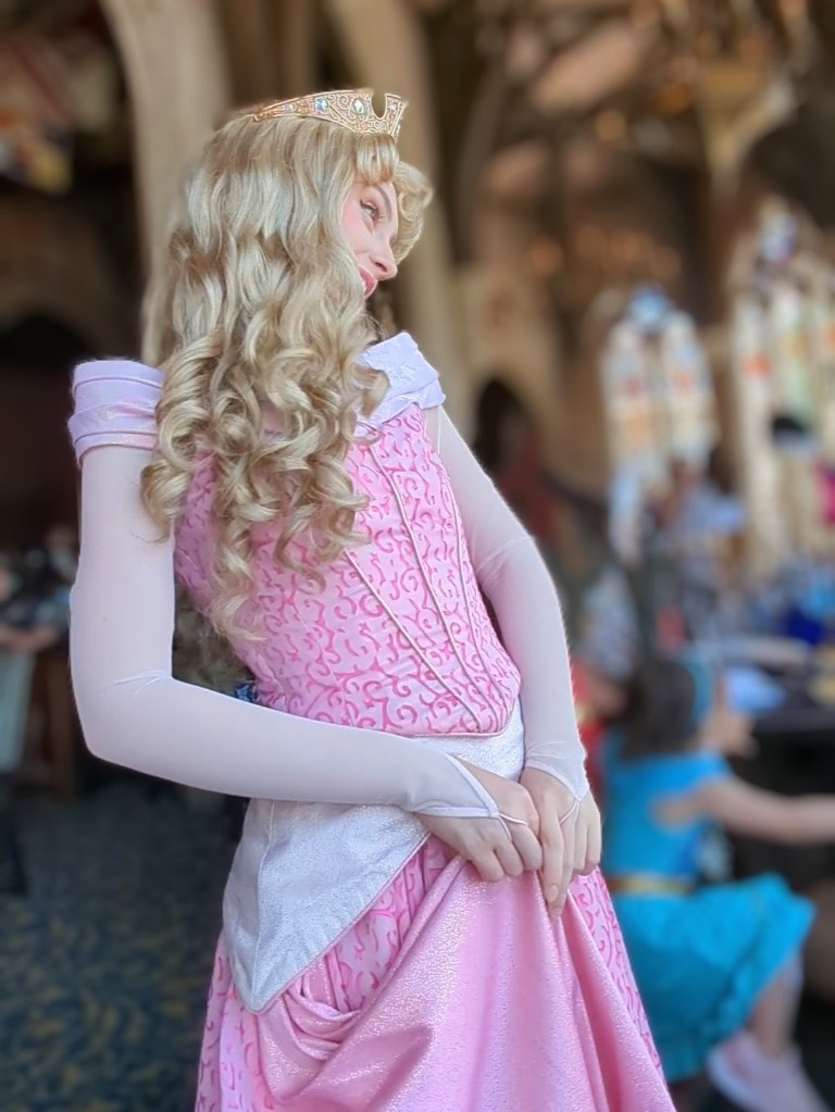 Aurora, also known as Sleeping Beauty, sweetly smiles during a Cinderella's Royal Table princess meal