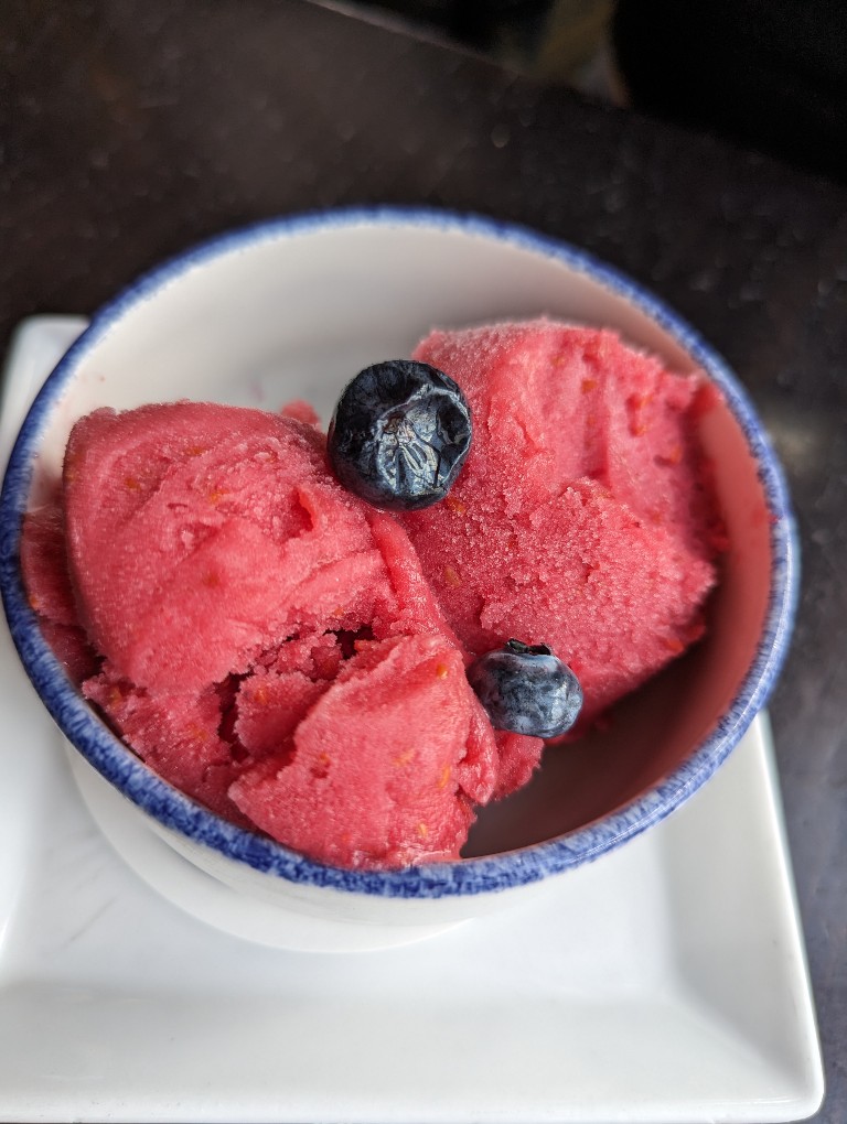 Two decadent scoops of raspberry sorbet sprinkled with blueberries is often an off-menu dessert at Cinderella's Royal Table