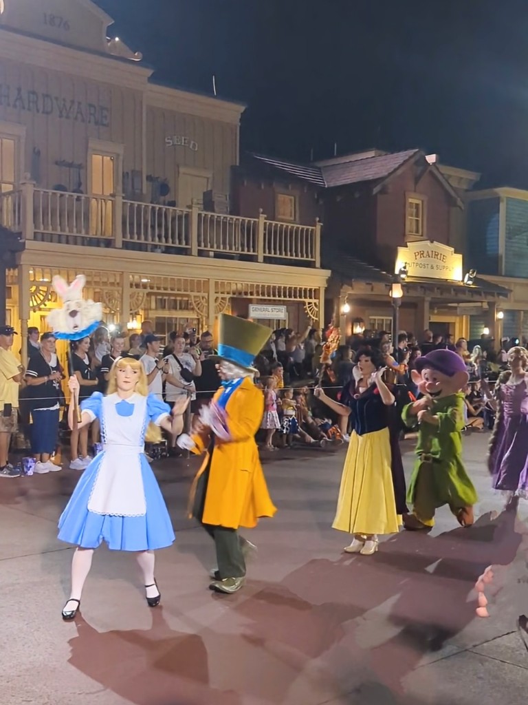Alice in Wonderland, the Mad Hatter, Snow White, Dopey, and Rapunzel wave and interact with guests during Mickey's Not So Scary Halloween Party Boo To You Parade