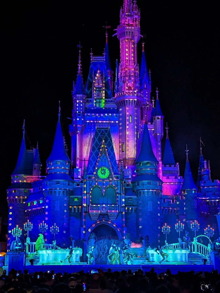 Hocus Pocus Villain Spelltacular characters dance on a stage in front of Cinderella Castle during Mickey's Not So Scary Halloween Party