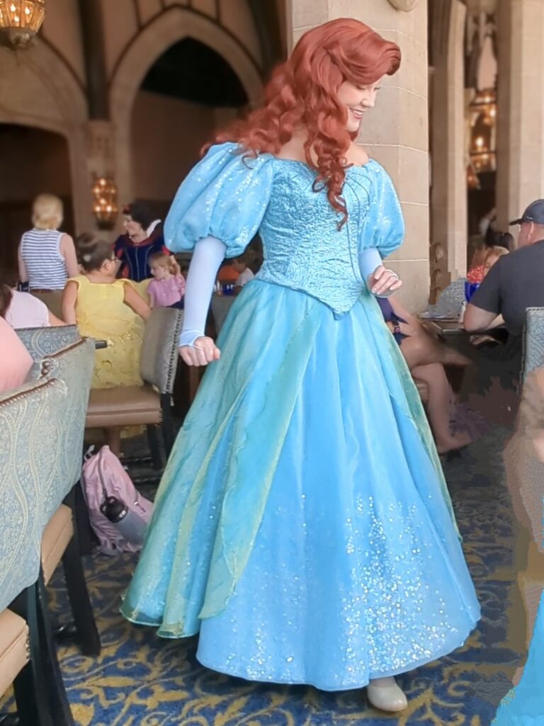 Ariel, based on the animated story, glides to a table in her gorgeous teal dress