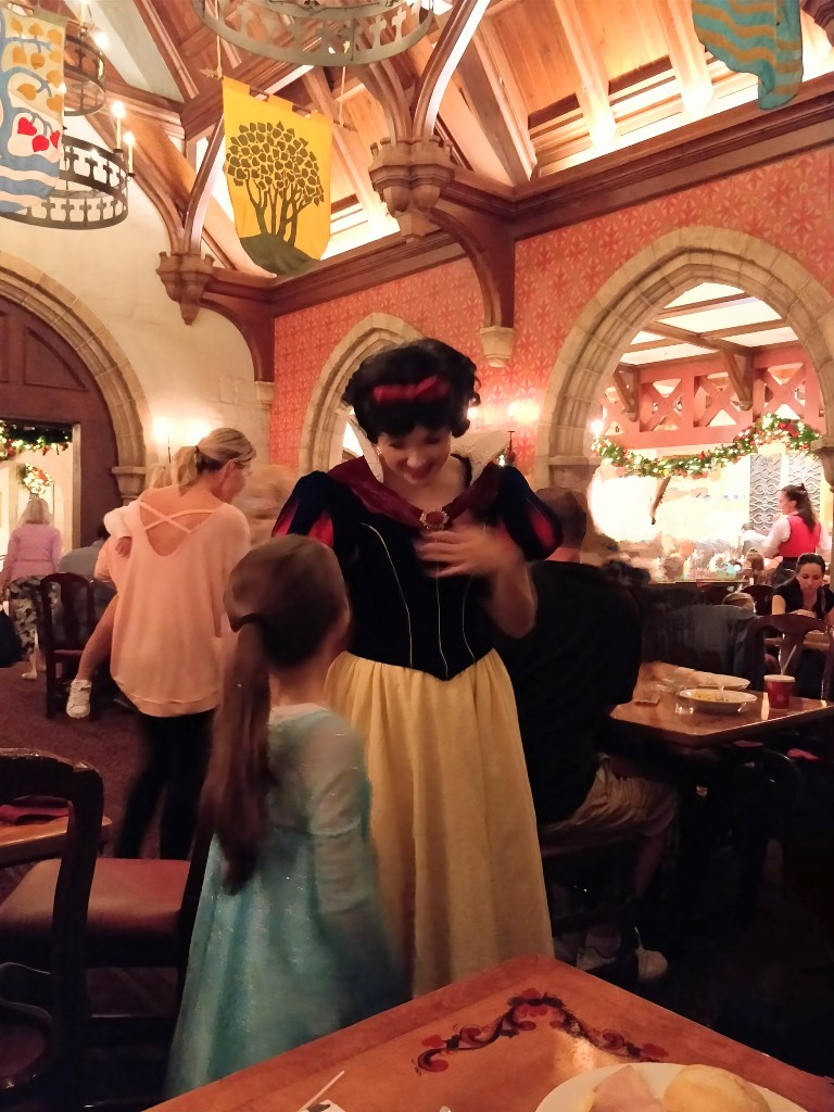 A girl looks up at Snow White inside Akershus Royal Banquet Hall