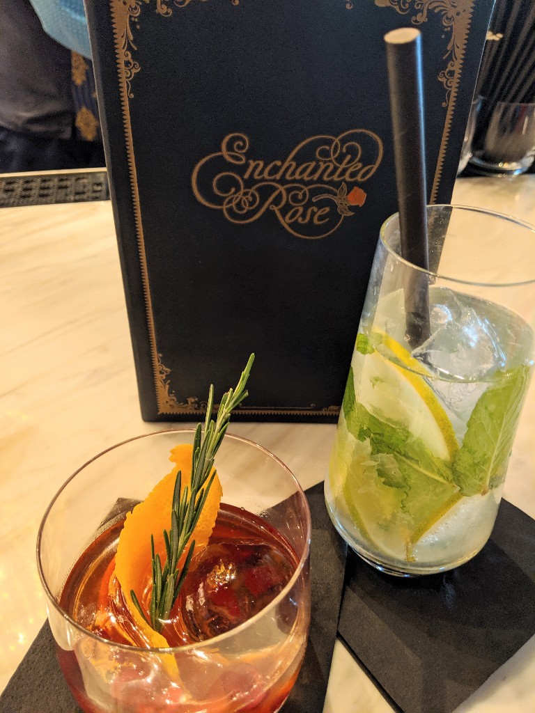Beautifully prepared cocktail and mocktail with a Enchanted Rose menu propped behind them