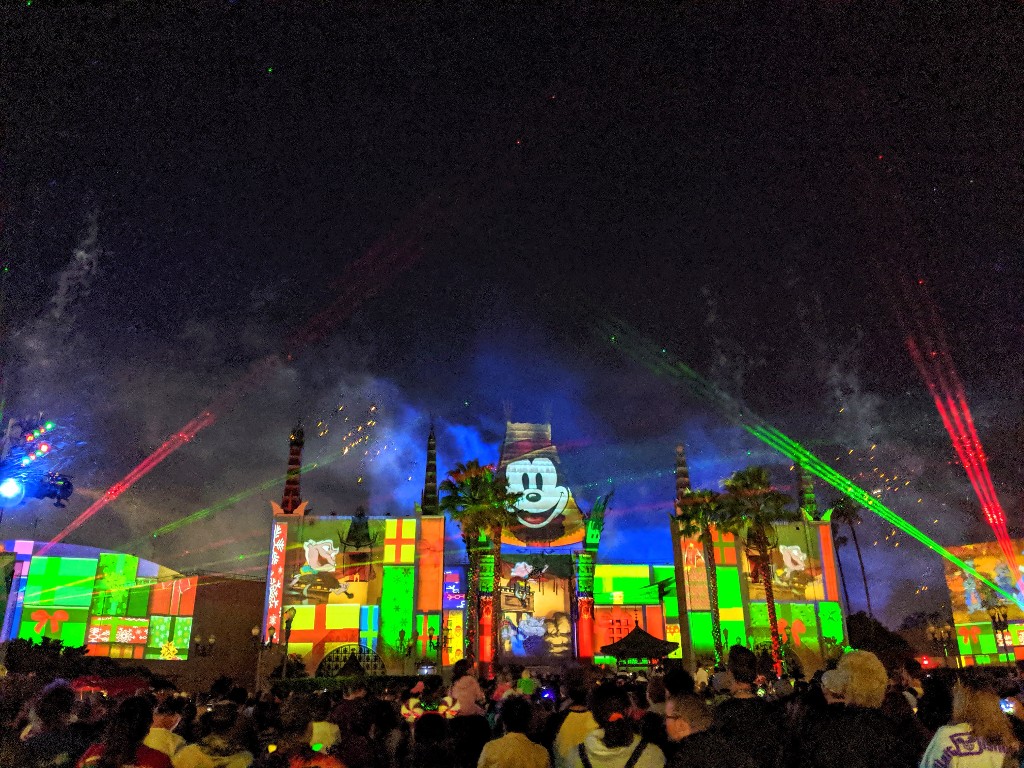 Mickey and other characters projected on Mickey and Minnie's Runaway Railway during Jingle Bell, Jingle BAM! fireworks at Hollywood Studios