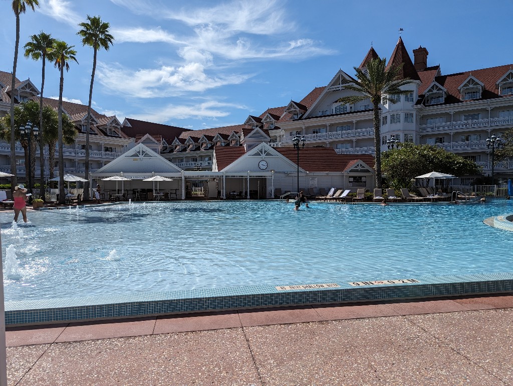 Disney's Grand Floridian Resort leisure pool shimmers in the sun with views of Grand Floridian Resort outer buildings in the background