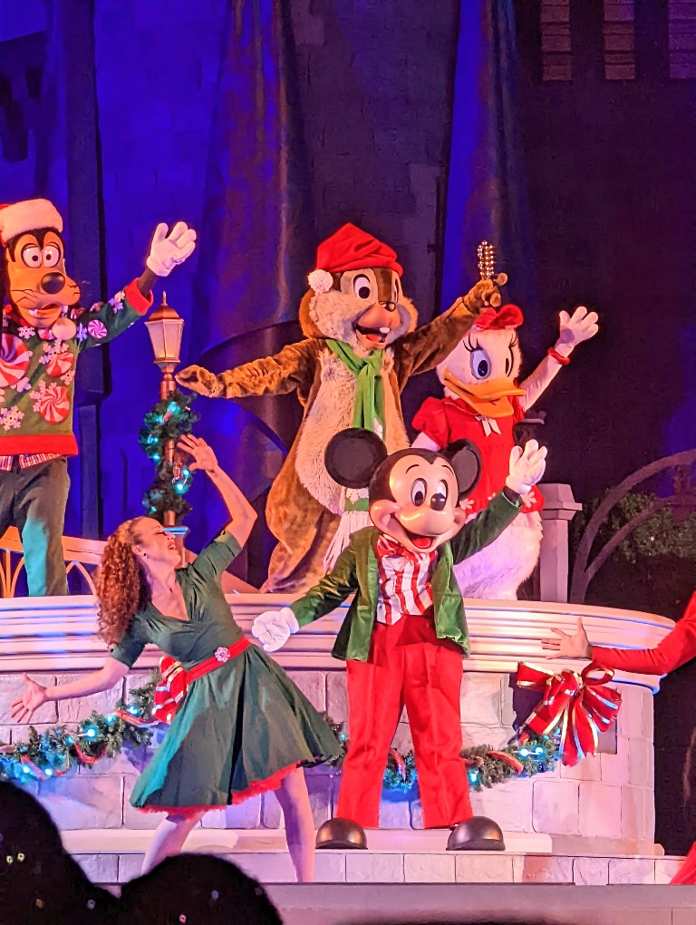 Mickey, Daisy, Goofy, Chip and Dale dressed in their finest holiday outfits perform in front of Cinderella Castle during Mickey's Very Merry Christmas Party