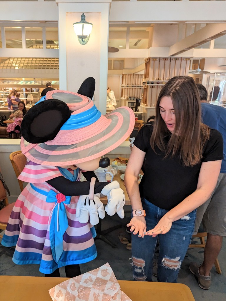 Minnie Mouse admires a woman's manicure at Cape May Cafe character breakfast