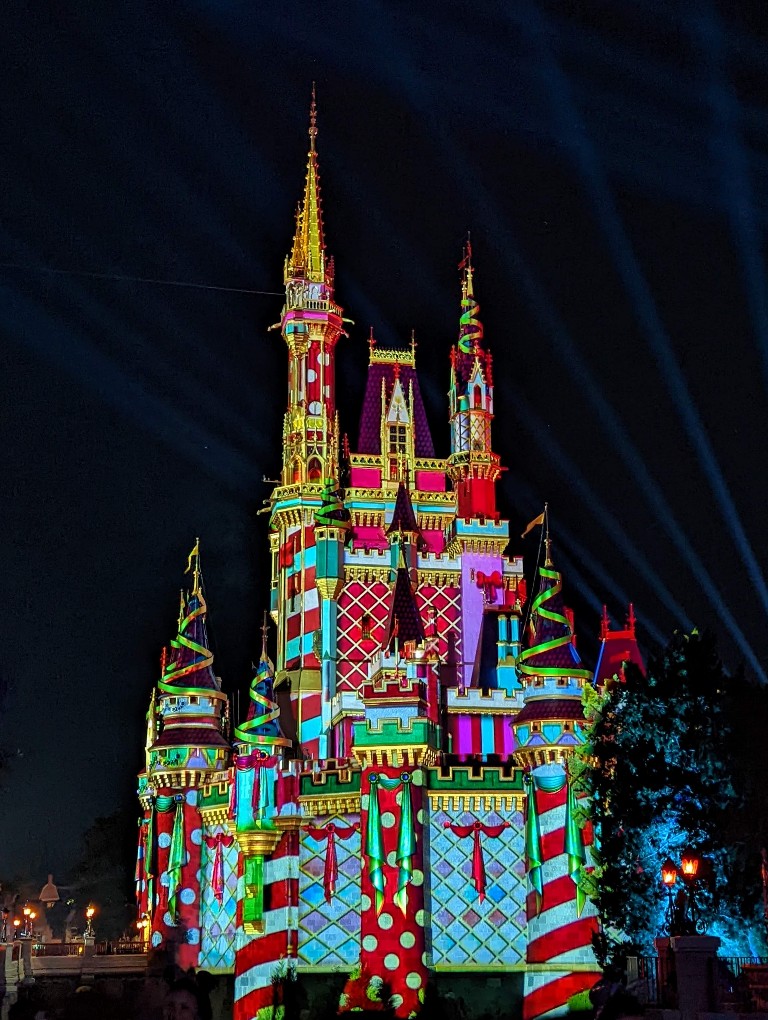 Cinderella Castle with holiday projections like candy cane stripes, polka dots, and green bows