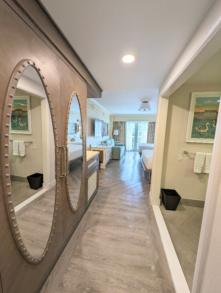 A hallway leads past a large closet and bathroom sinks to the spacious 5th sleeper room at Disney's Boardwalk Inn