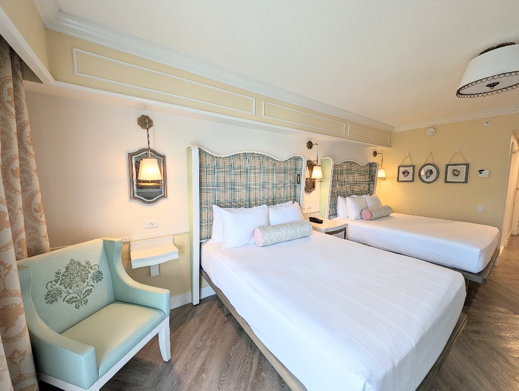A pale green and yellow plaid headboard frames white bed linens in the newly remodeled Boardwalk Inn rooms