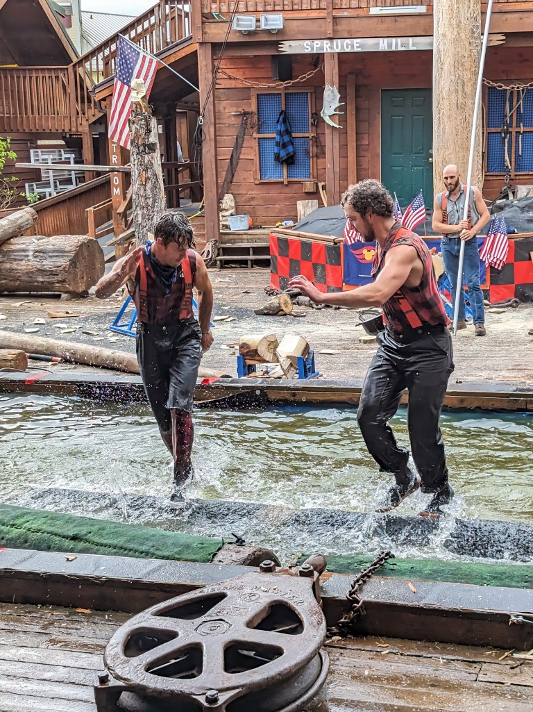 Two lumberjacks run atop a floating log trying to distract one another and win the competition