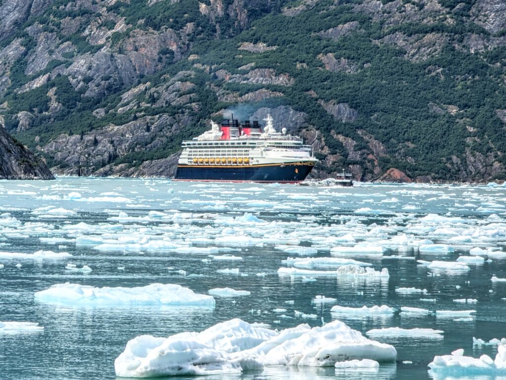 Disney Wonder with mountains in the background and ice filled water in front during a Disney Alaska Cruise